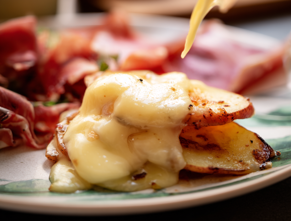 photo d'une raclette dans une assiette avec du fromage et charcuterie
